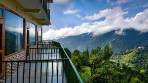 a balcony with a view of a mountain at pristine mountain lodge in Chail