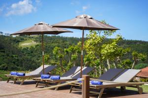 a group of lounge chairs and umbrellas at Quinta da Abelheira 1660 in Sobral da Abelheira