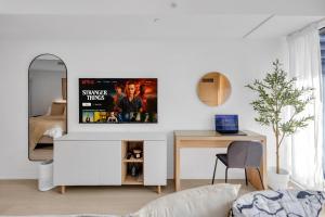 a living room with a tv on a wall at Work-Friendly 1BR Suite Steps to Eaton Centre in Toronto