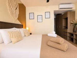 a bedroom with a large white bed with towels on it at Syrena Luxury Caribbean - Heart of Playa del Carmen - Sea Views in Playa del Carmen