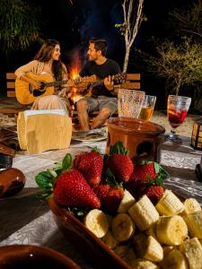 a group of people sitting around a table with strawberries at Casa da Vovó na Pousada Sitio Pauletto - com Cozinha, Churrasqueira e Decoração in Jarinu