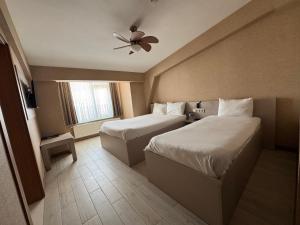 a hotel room with two beds and a ceiling fan at Hotel Cinas in Eskisehir