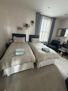 a bedroom with two beds with pillows on them at Lazy Waves in Newquay +51 photos