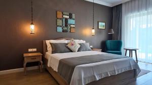 a bedroom with a bed and a blue chair at D&C Göcek Hotel in Göcek +36 photos