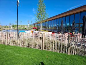 a fence with tables and umbrellas in front of a building at Huis Pimpernel in Bredene