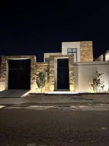 two garage doors on a building at night at شاليه بالم ون و فيلورا الفندقي in Buraydah