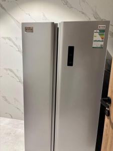 a white refrigerator freezer sitting in a kitchen at شاليه بالم ون و فيلورا الفندقي in Buraydah