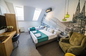 a bedroom with a bed and a couch and a chair at Grand Danube Hotel in Komárno