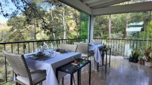 two tables on a balcony with a view of trees at D&C Göcek Hotel in Göcek