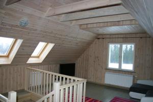 a room with wooden walls and ceilings with windows at Põhjakalda in Nüpli +14 photos