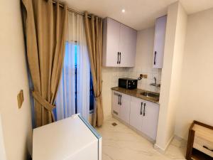 a small kitchen with white cabinets and a sink at Motorway Majesty Heights - Near Islamabad International Airport and Motorway in Islamabad