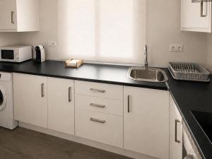 a kitchen with a sink and a counter top at Hospedium GL Linarejos Suites Parking Gratis in Linares +11 photos