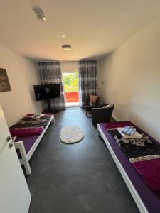 a room with two beds and a living room at Ferienwohnung Hercules in Meinerzhagen