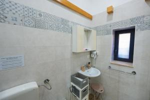 a bathroom with a sink and a toilet and a window at Il Cortile della Patrona in Syracuse +50 photos