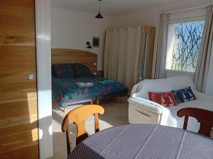 a bedroom with a bed and a table and chairs at domaine de marodi jasmin in Baignes-Sainte-Radegonde