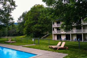 a hotel with a swimming pool and two lounge chairs at Seasons 304 in Warren