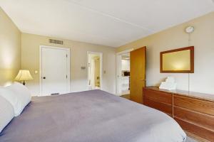 a bedroom with a large bed and a wooden dresser at Seasons 304 in Warren +10 photos