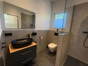 a bathroom with a sink and a toilet at Ferienhaus Lenz in Kalenborn