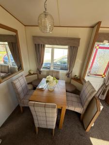 a dining room with a wooden table and chairs at Jemmas Holiday Home in Arbroath