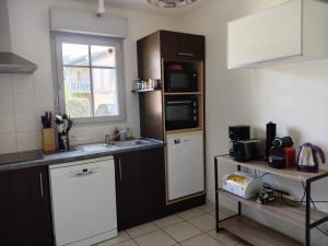 a kitchen with a sink and a microwave at La gemmeuse Meublé de tourisme 3 étoiles in Aureilhan