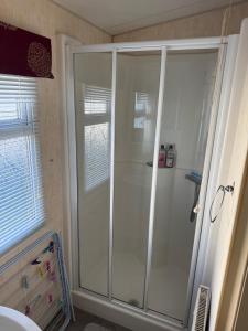 a bathroom with a shower with a glass door at Jemmas Holiday Home in Arbroath +15 photos