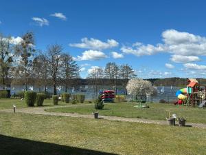a park with a playground next to a body of water at KAMERALNY przy promenadzie - pokoje in Charzykowy