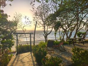 a view of the beach with a bench and a table at Xalli Beach Hotel in Altagracia