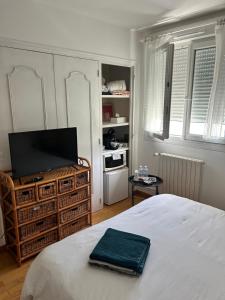 a bedroom with a bed and a flat screen tv at Le Korrigan in Saint-Jacques-de-la-Lande