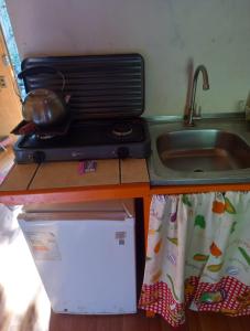a kitchen counter with a sink and a toaster oven at Cabañita en la Isla in Isla Negra