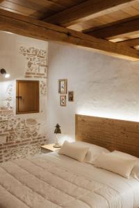 a bedroom with a large bed with a brick wall at Locanda delle rose in Roccavaldina