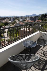 a balcony with two chairs and two tables on it at Celuga sea view apartments in Bar