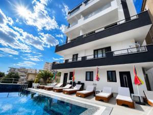 a hotel with a pool in front of a building at DAK Suites in Sarandë