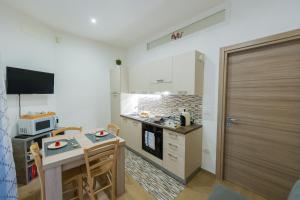 a small kitchen with a table and a microwave at Il Cortile della Patrona in Syracuse