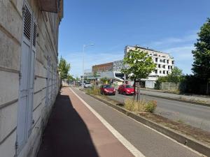 a street with cars parked on the side of a building at Duplex Kedge Talence in Talence