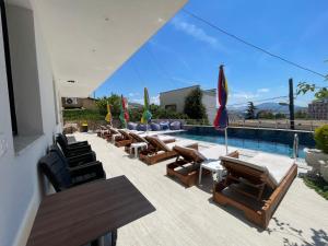 a swimming pool with lounge chairs and a swimming pool at DAK Suites in Sarandë