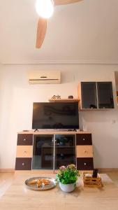 a living room with a large tv and a table at Apartalux Magic Platinum in Oropesa del Mar