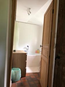 a bathroom with a tub and a sink and a door at mini caravane teardrop in Saint-Denis