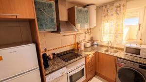 a small kitchen with a sink and a microwave at Apartalux Magic Platinum in Oropesa del Mar