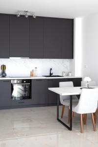 a kitchen with black cabinets and a table and chairs at Celuga sea view apartments in Bar