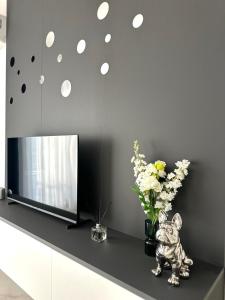 a vase of flowers on a counter next to a television at Celuga sea view apartments in Bar