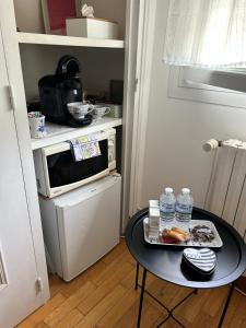 a small kitchen with a table in front of a microwave at Le Korrigan in Saint-Jacques-de-la-Lande