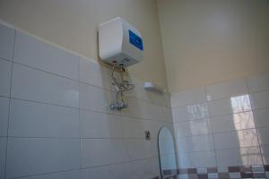 a bathroom with a paper towel dispenser on the wall at Rostel Villa Hotel in Mbeya +84 photos