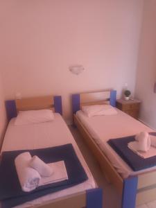 a room with two beds with towels on a tray at nostalgo in Skiathos +6 photos