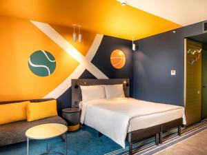 a bedroom with a bed and a couch at ibis Styles Batumi Hotel in Batumi