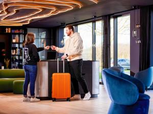 a man and a woman shaking hands in an office at TRIBE Milano Malpensa in Vizzola Ticino +142 photos