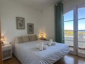 a bedroom with a bed with white sheets and a window at White Sands 3.08 in Arenal d'en Castell +22 photos