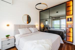 a bedroom with a large white bed and a mirror at Maria Premium BELLA VISTA in Baošići