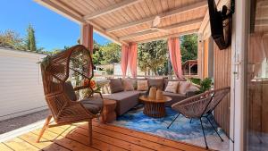 a patio with a couch and chairs on a porch at Iris Holiday Homes in Biograd na Moru