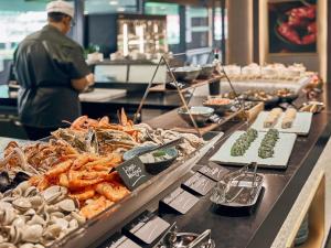 a buffet line with seafood on display in a restaurant at Mercure ICON Singapore City Centre in Singapore