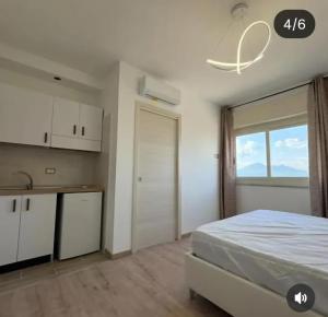 a bedroom with a bed and a kitchen with a window at B&b Antonia in SantʼAntonio Abate